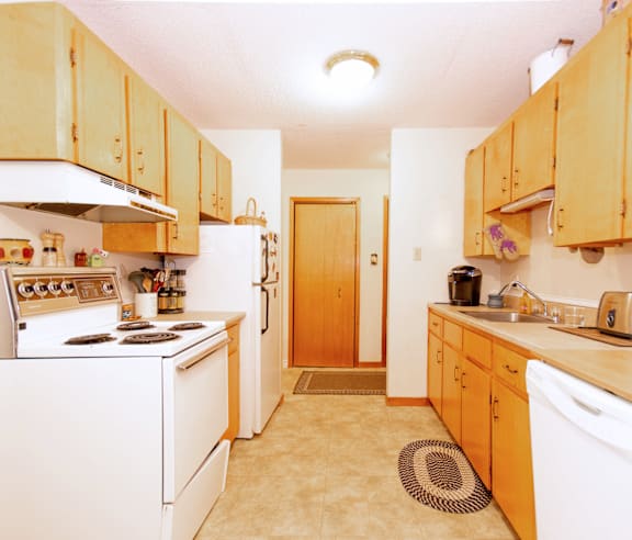 A kitchen with wooden cabinets and white appliances.