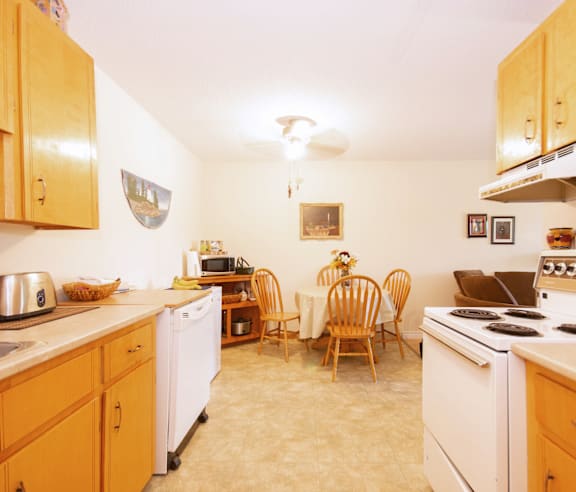 A kitchen with wooden cabinets and a white dishwasher.