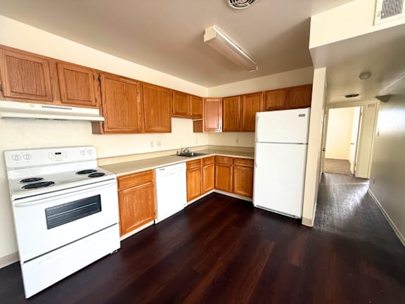 A kitchen with white appliances and wooden cabinets. at Townview Plaza Apartments , Colorado, 80204