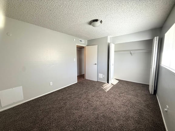 A room with carpeted floor and a doorway leading to another room at Mountain Terrace Apartments , Westminster, Colorado