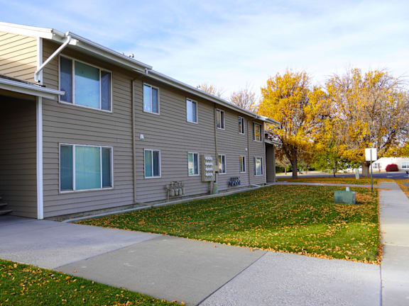 A building with a grey siding and a white roof at Grand Manor Apartments , Grand Junction