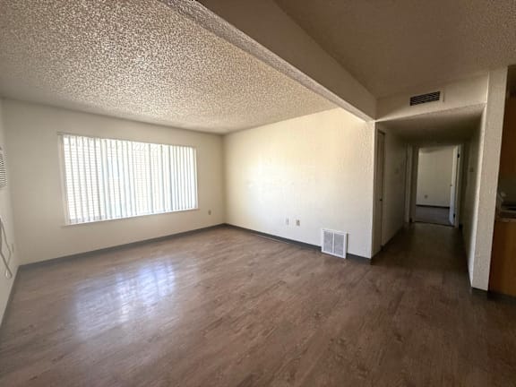 A room with wooden flooring and a window with blinds at Grand Manor Apartments , Colorado, 81501