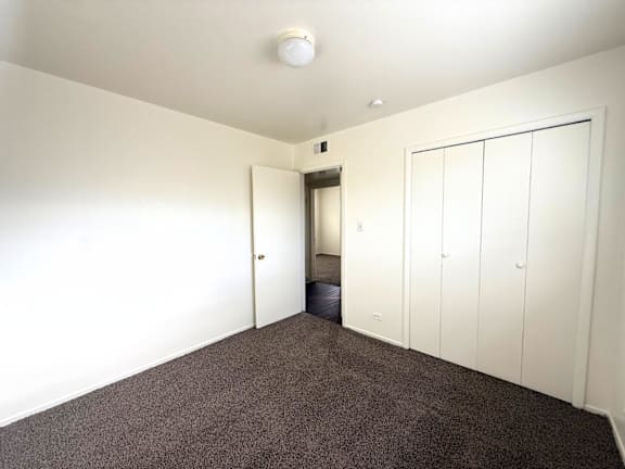 A room with a carpeted floor and a white ceiling with a smoke detector. at Townview Plaza Apartments , Denver