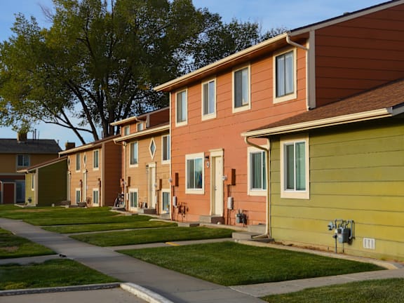 A row of houses with green lawns in front. at Willow Grove Apartments , Clifton, CO, 81520