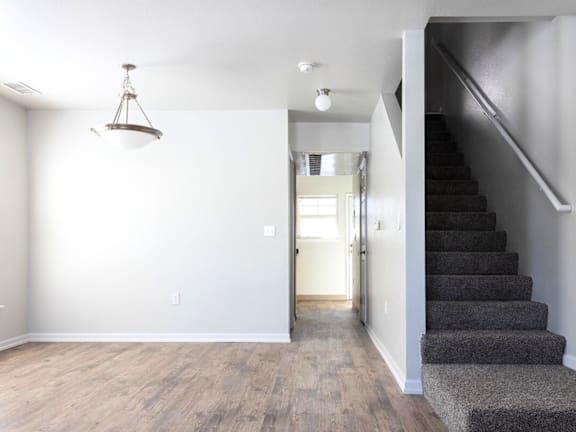 A room with a staircase and a light hanging from the ceiling. at Meeker Commons Apartments , Greeley, CO, 80631
