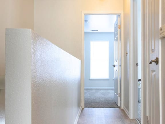 A white door is open to a hallway. at Meeker Commons Apartments , Greeley, CO