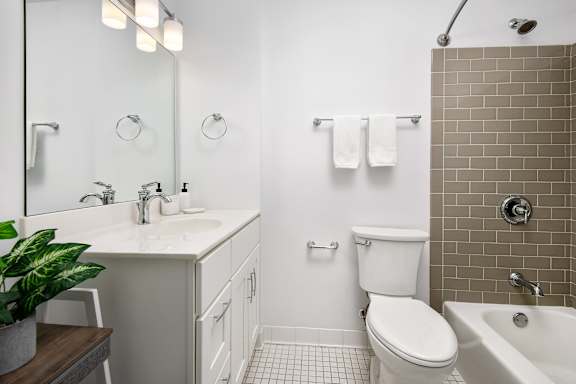 A white toilet sits in a bathroom next to a white sink.