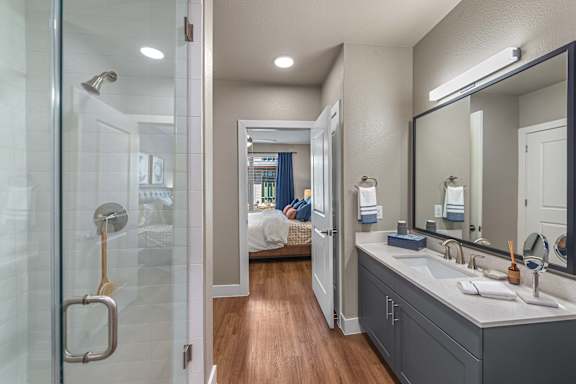 A bathroom with a walk in shower and a double sink vanity.