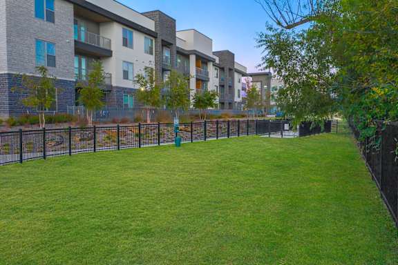 A grassy area in front of apartment buildings.