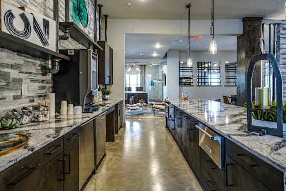 A modern kitchen with dark wood cabinets and a marble countertop.
