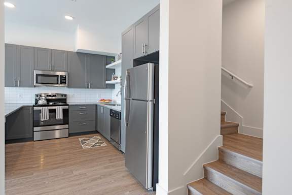 a kitchen with gray cabinets and stainless steel appliances  at Presidium Pecan District, Pflugerville, 78660