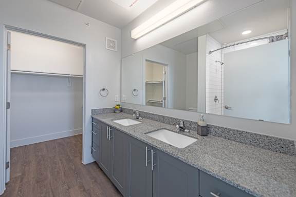 a bathroom with two sinks and a large mirror  at Presidium Pecan District, Pflugerville, 78660