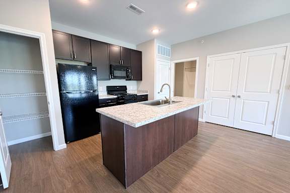 Modern kitchen with island and granite countertops at The Meridian on 32 Apartments, Ohio