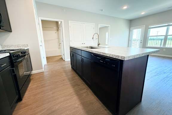 Kitchen island with sink and dark cabinetry at The Meridian on 32 Apartments, Ohio, 45103