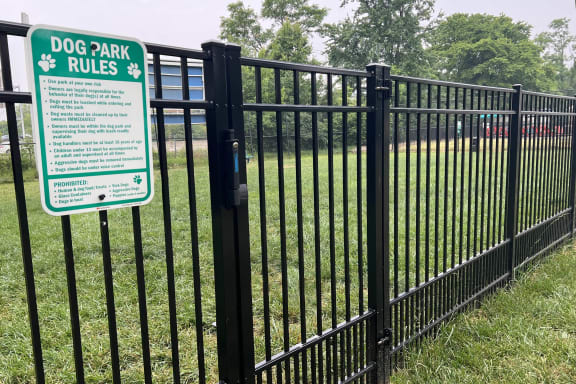 a black fence with a sign that says dog park rules  at Hunter's Creek Apartments, Cincinnati, Ohio