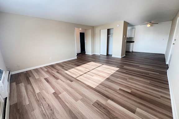 A room with wooden flooring and white walls.