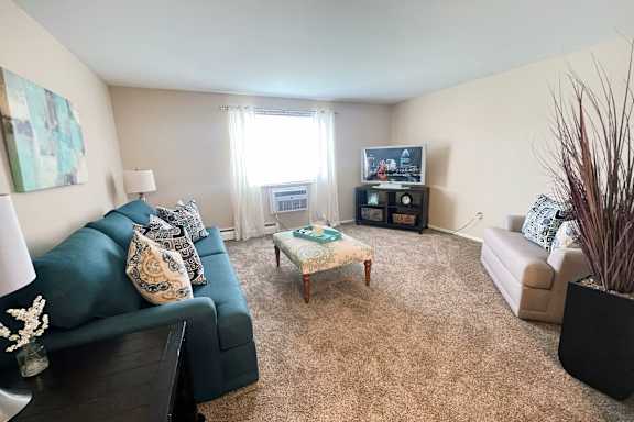 A living room with a dark blue couch, a coffee table, and a television.