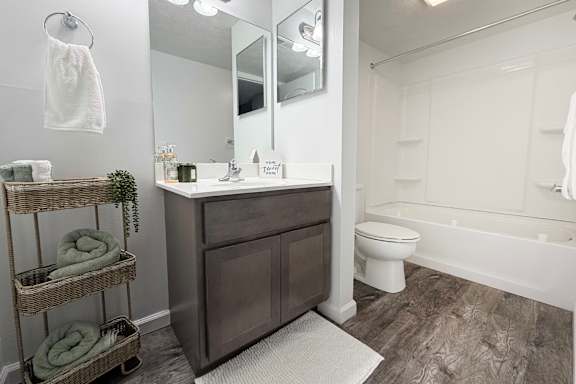 A bathroom with a white toilet and a white bathtub.