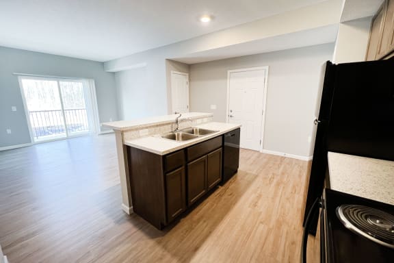 an empty kitchen and living room with wood flooring and a window  at Brookfield Village Apartments, Grove City, OH, 43123