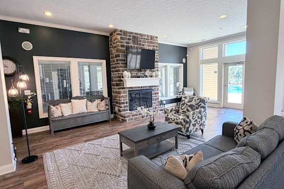 A living room with a grey couch, a fireplace, and a television.