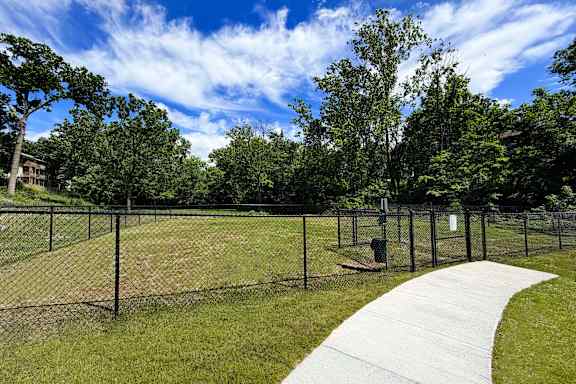 A park with a fence and a walkway.