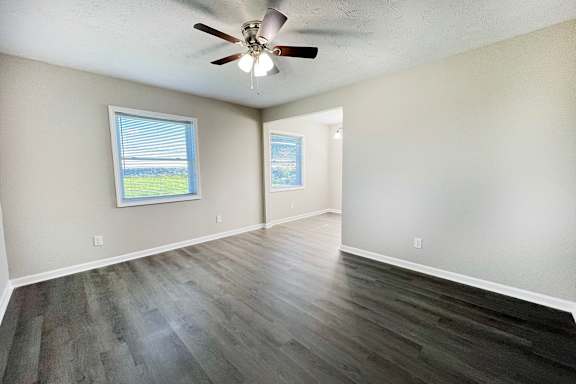 A room with a ceiling fan and a window.
