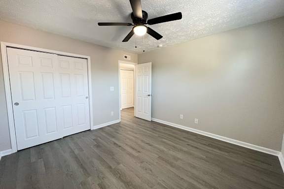 A room with a ceiling fan and two doors.