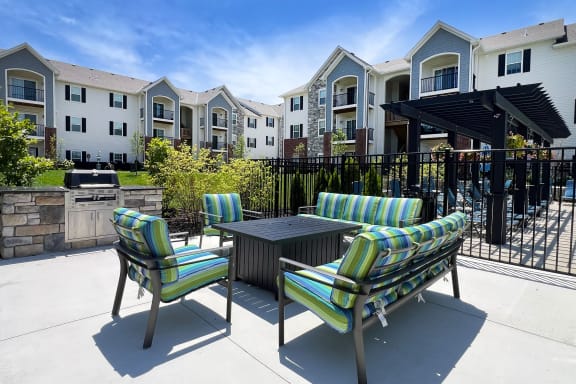 a patio with chairs and a table in front of an apartment building at Parkway Trails, Florence