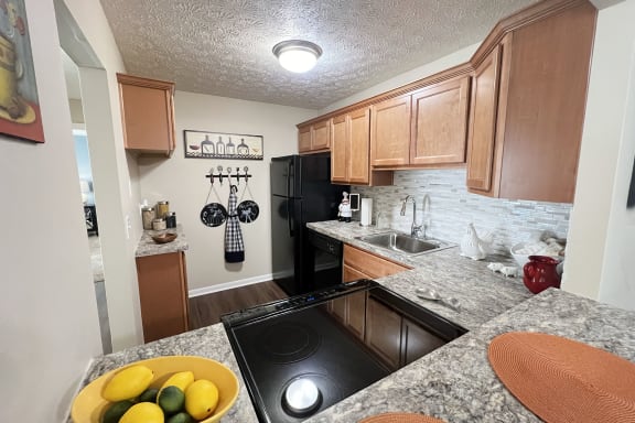 full kitchen with black appliances and granite countertops at the preserve  at Fox Run Apartments, Cincinnati, OH, 45236