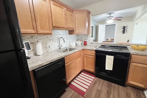 a kitchen with black appliances and wooden cabinets  at Fox Run Apartments, Cincinnati, OH, 45236