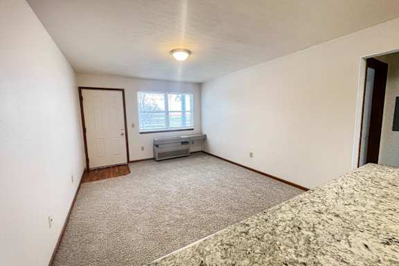 A bedroom with a bed, dresser, and window.