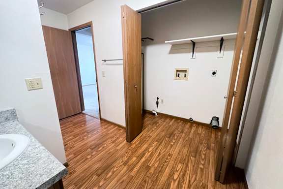 A bathroom with a wooden floor and a sink.