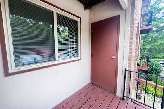 A red door is on the right side of a white wall.