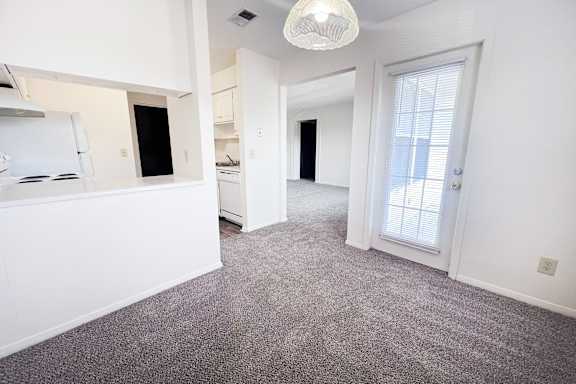 A room with a grey carpet and white walls.