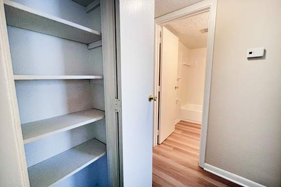 A white refrigerator with four shelves is open.