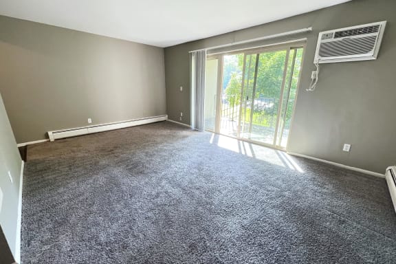 an empty living room with grey carpet and a sliding glass door at Crown Pointe Apartments, Kentucky, 41014