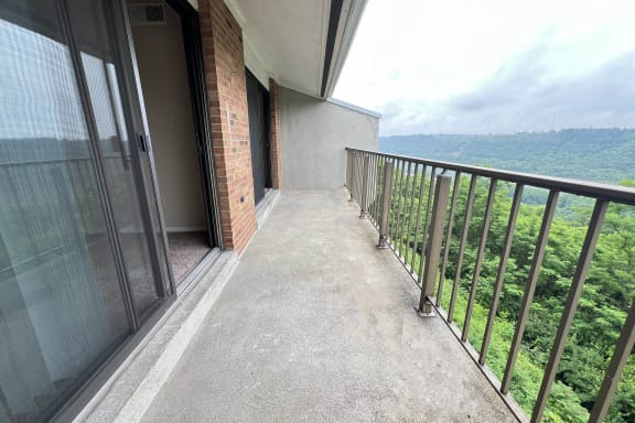 a balcony with a view of a building and some trees