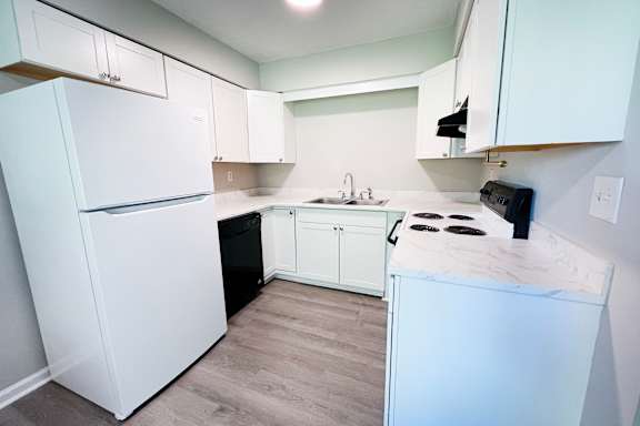 A kitchen with white appliances and cabinets.
