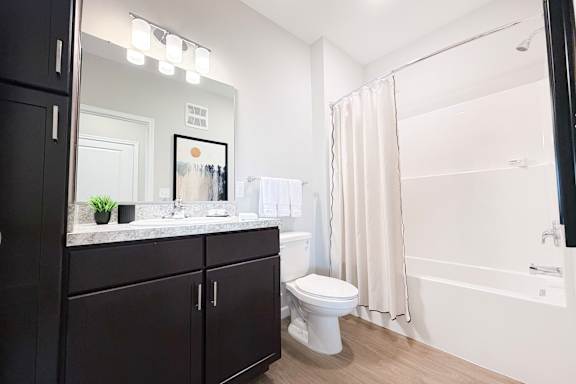 Modern bathroom with dark vanity and granite countertop at The Meridian on 32 Apartments, Batavia, Ohio