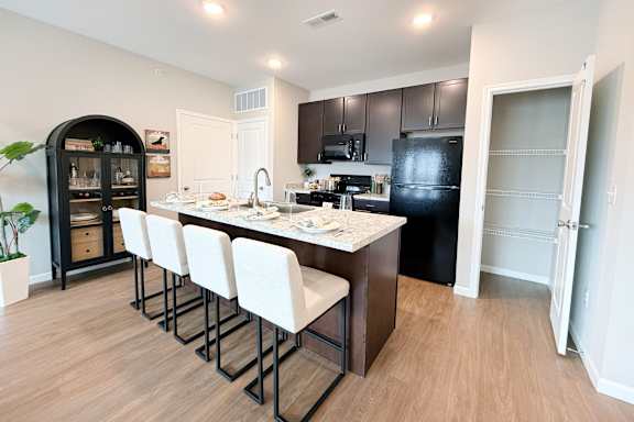 Kitchen with island seating and dark wood cabinets at The Meridian on 32 Apartments, Ohio