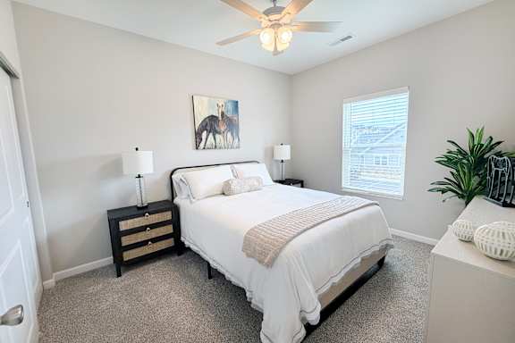Bedroom with neutral decor and artwork above bed at The Meridian on 32 Apartments, Ohio