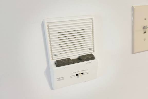 A wall-mounted air conditioner unit with a remote control.