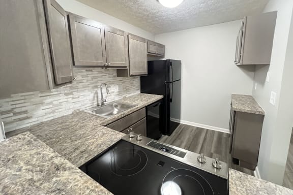 a kitchen with granite counter tops and a black stove and refrigerator  at Fox Run Apartments, Cincinnati, OH, 45236