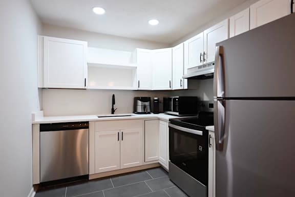 A modern kitchen with stainless steel appliances and white cabinets.