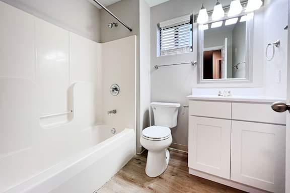 A white bathroom with a toilet, sink, and bathtub.