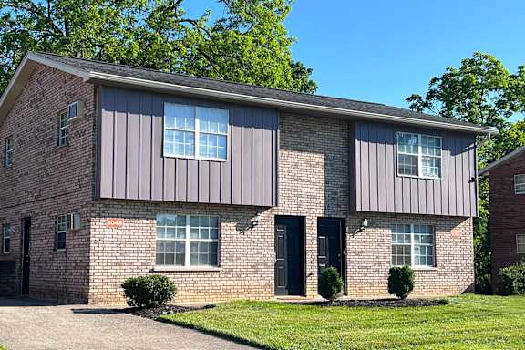 A brick house with a black door and windows.