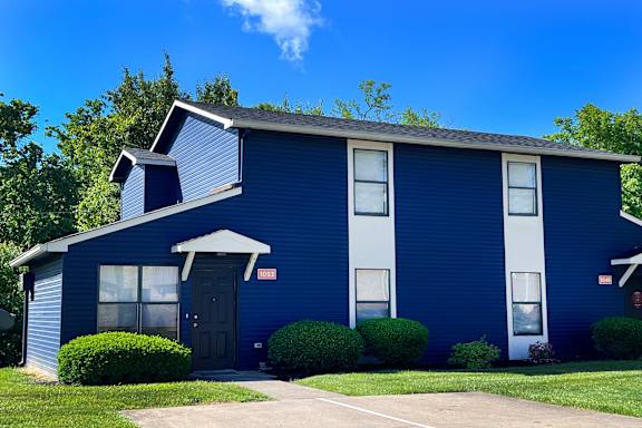 A blue house with a black door and windows.