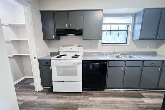A kitchen with a white stove and black oven.