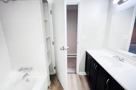A white bathroom with a white tub and sink.