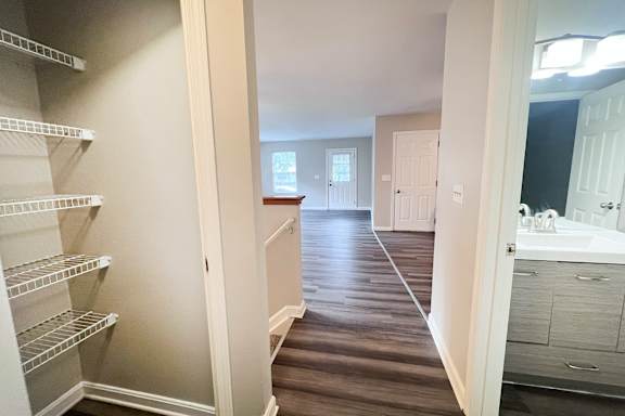 A hallway with a pantry and a bathroom at the end.